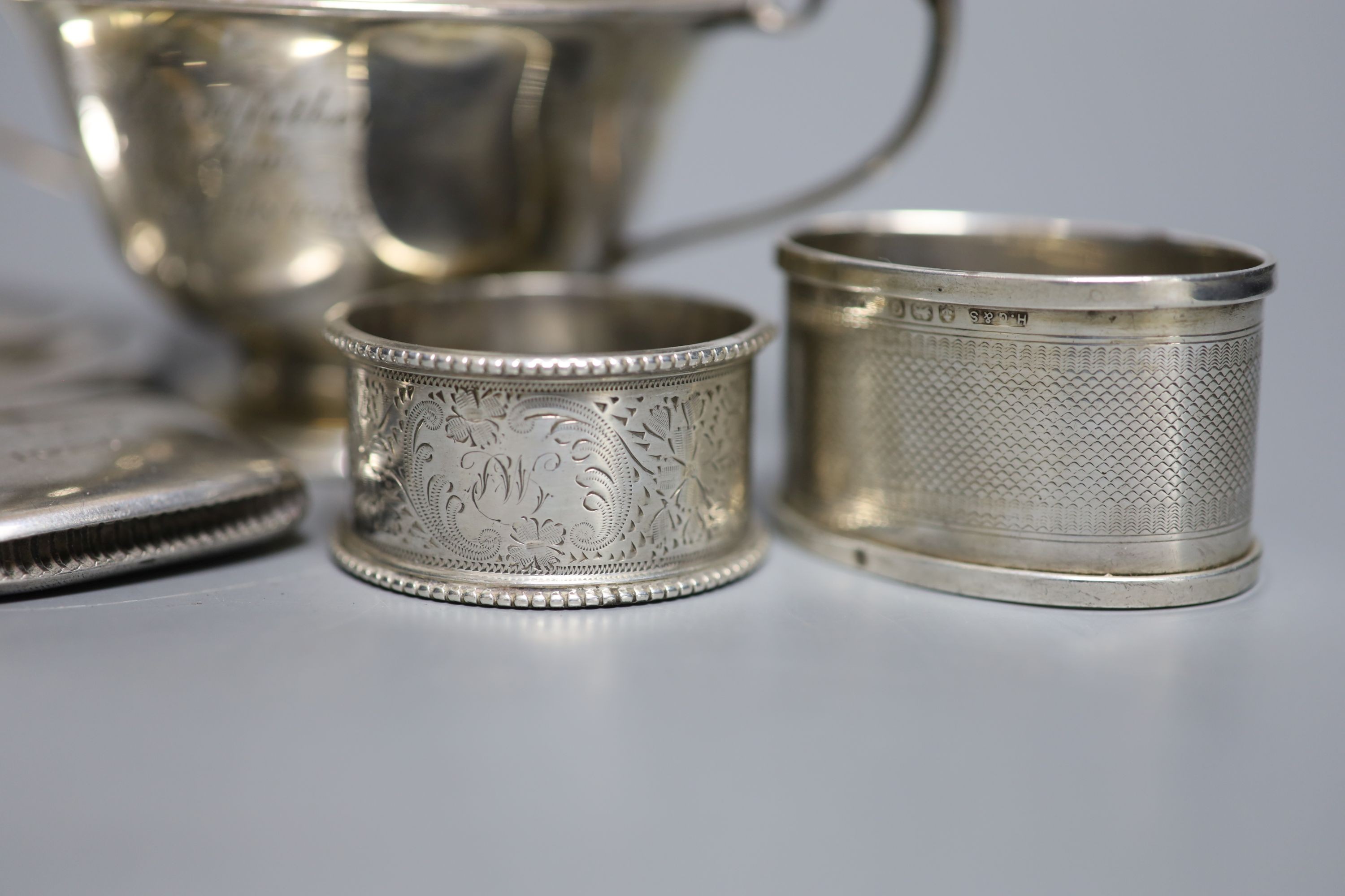 A Scottish silver mounted oval inkwell, 13.2cm, a small silver bowl, silver vesta case, silver cigarette case, two silver napkin rings and two other items.